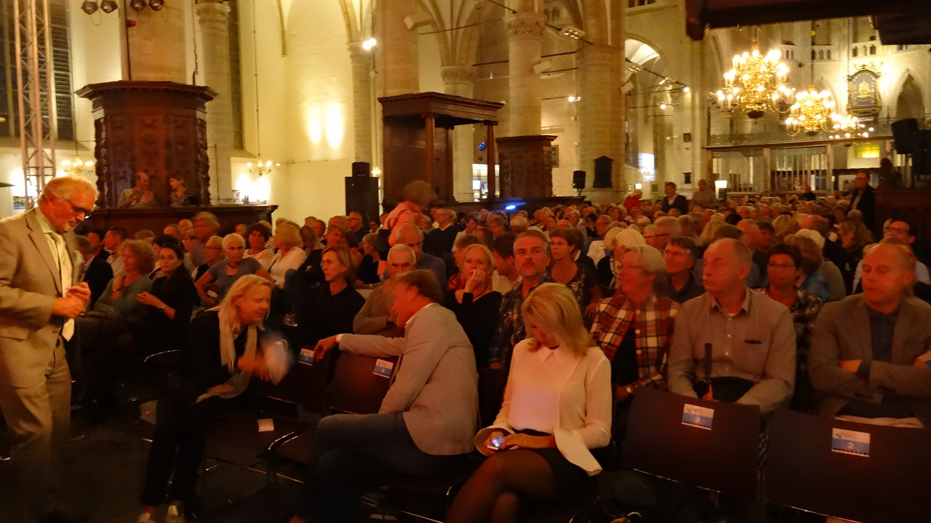 Publiek, waaronder ook onze burgemeester (links), zoekt zijn plek weer op - Foto: Jaap 't Hooft